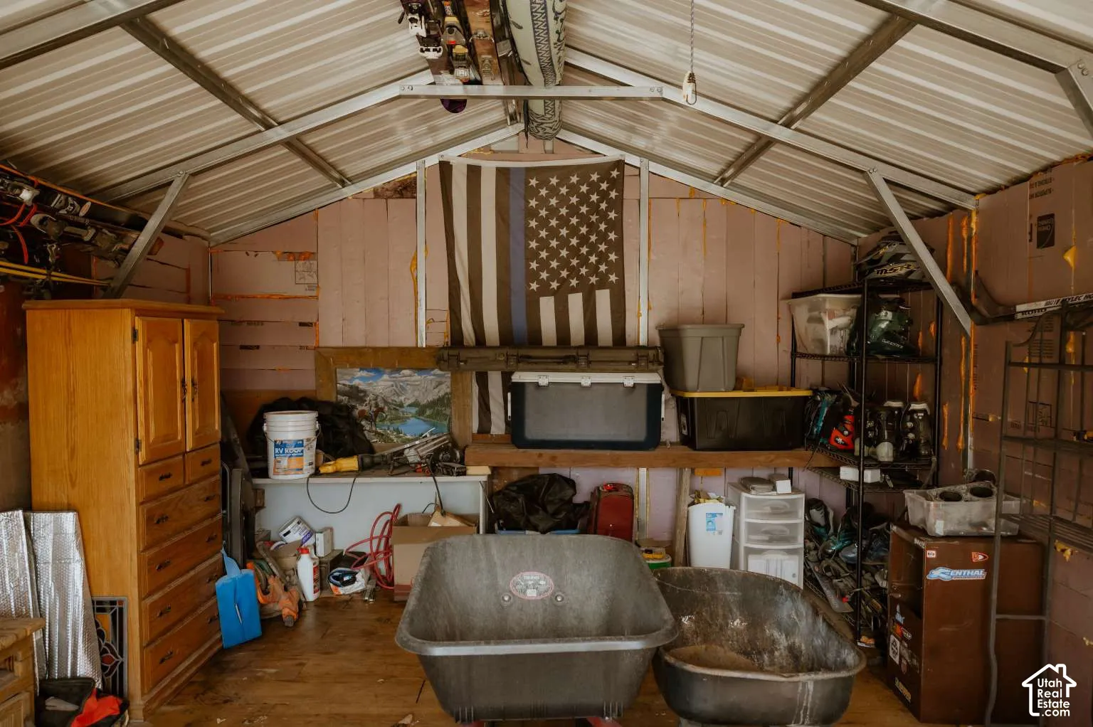 Storage structure featuring a metal-frame gabled roof, rigid foam wall insulation, and wood-plank flooring