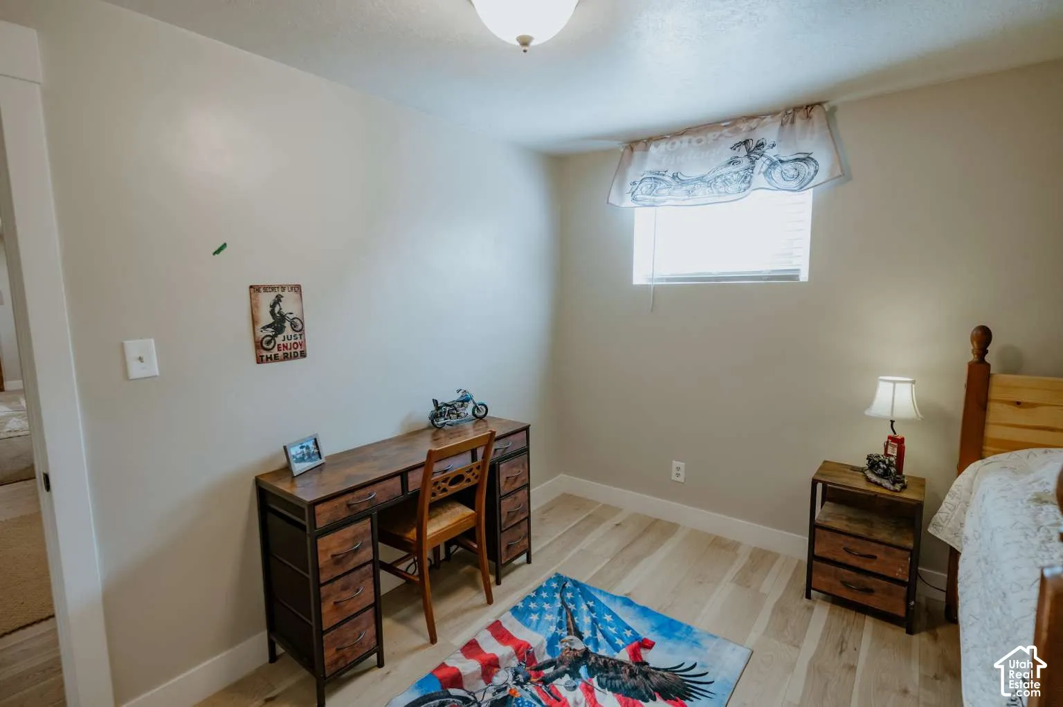 Neutral interior walls, wood-finish flooring, and single-pane window with top-mount hardware