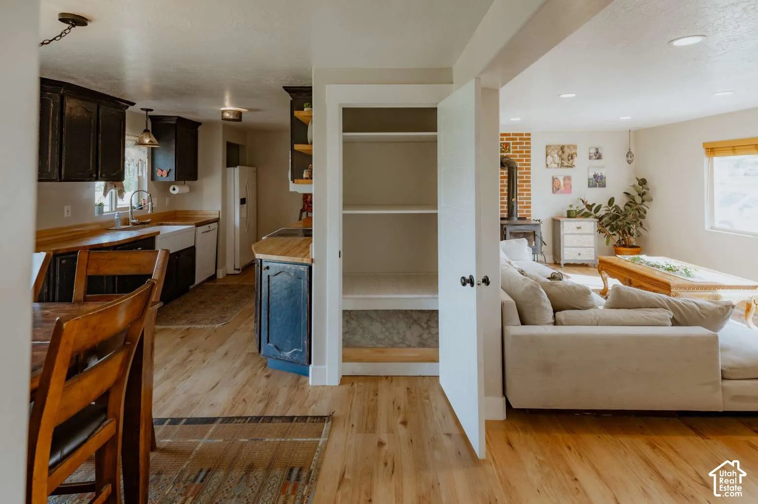 Kitchen area featuring dark cabinetry, wood-finish countertops, and an apron-front sink