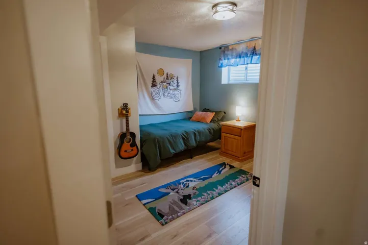 Light wood-finish flooring with a ceiling-mounted flush light fixture