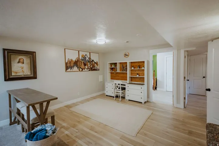Light wood-finish flooring with recessed lighting and a built-in storage and desk unit