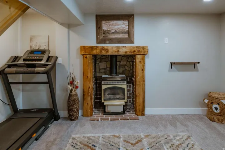 Wood-wrapped fireplace with a stone and brick surround, featuring a built-in stove