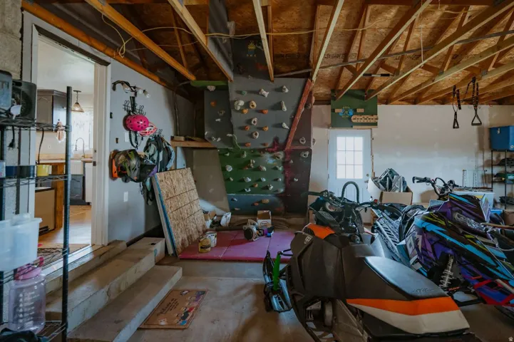 Exposed rafter ceiling, built-in climbing wall, finished concrete flooring, interior access door, exterior access door