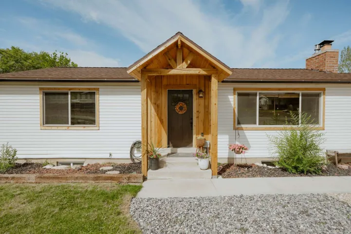 White siding exterior with a wood-frame entryway