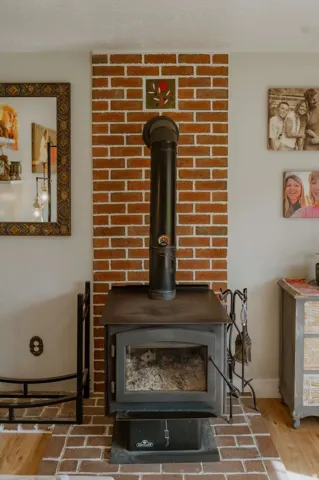 Wood-burning stove with a brick surround and a brick-patterned hearth