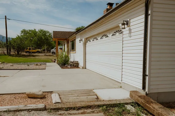 White horizontal siding exterior with an attached garage featuring decorative arched windows