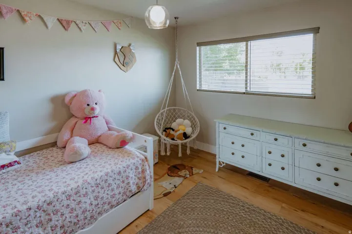 Wood-finish flooring, overhead lighting fixture, and a window with horizontal blinds