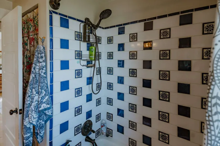 Tiled shower surround with decorative blue and white accents