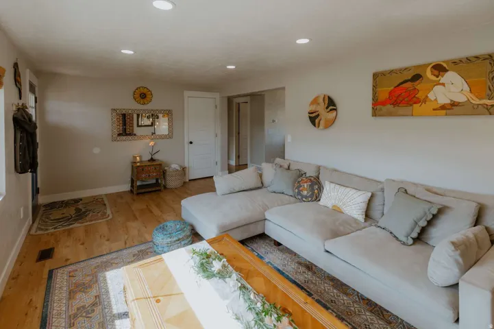 Light-toned wood-finish flooring, recessed lighting, and white trim