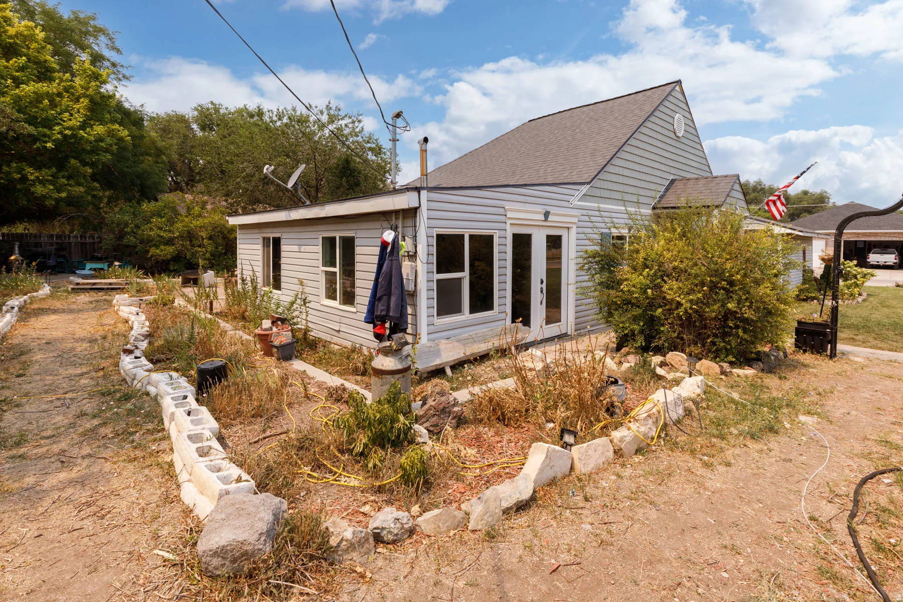Light blue horizontal siding, white trim, and a shingled roof