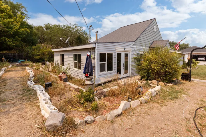 Light blue horizontal siding, white trim, and a shingled roof