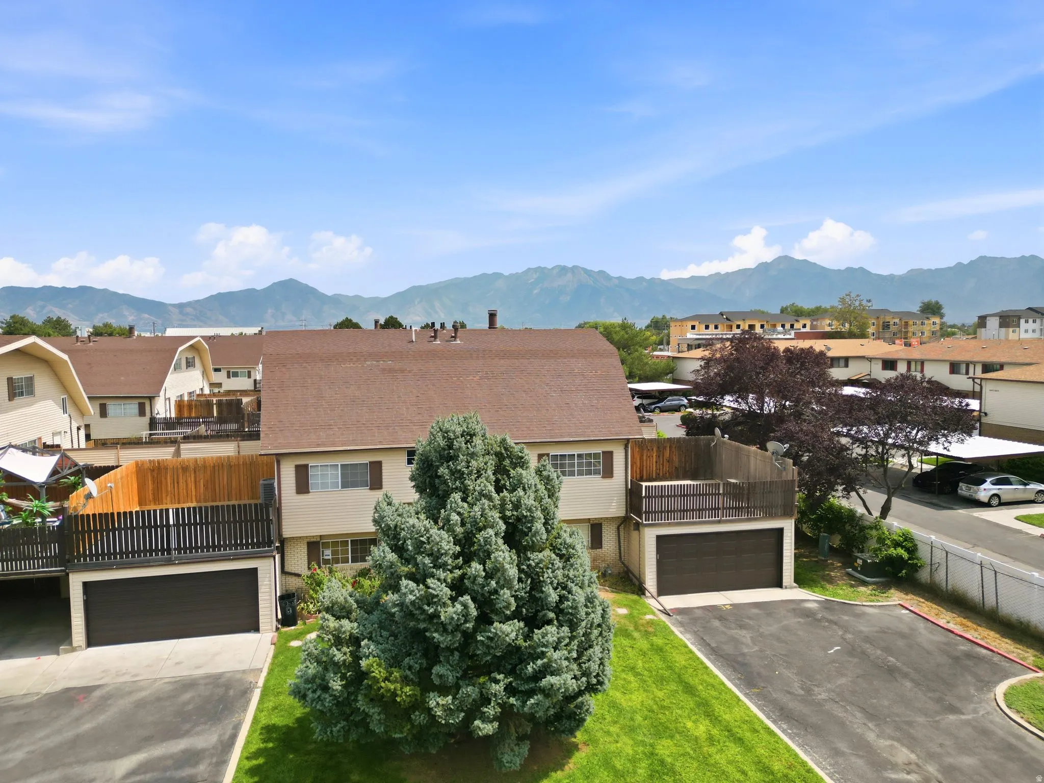 Townhome property with private garage, second-story patio, and mountain backdrop