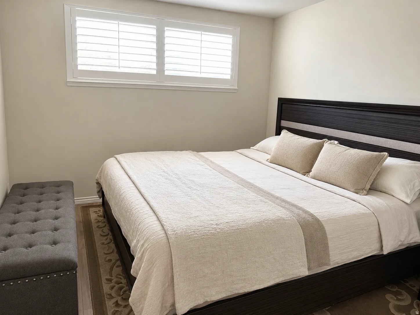 Wood-finish flooring, plantation shutters, and a built-in upholstered storage bench
