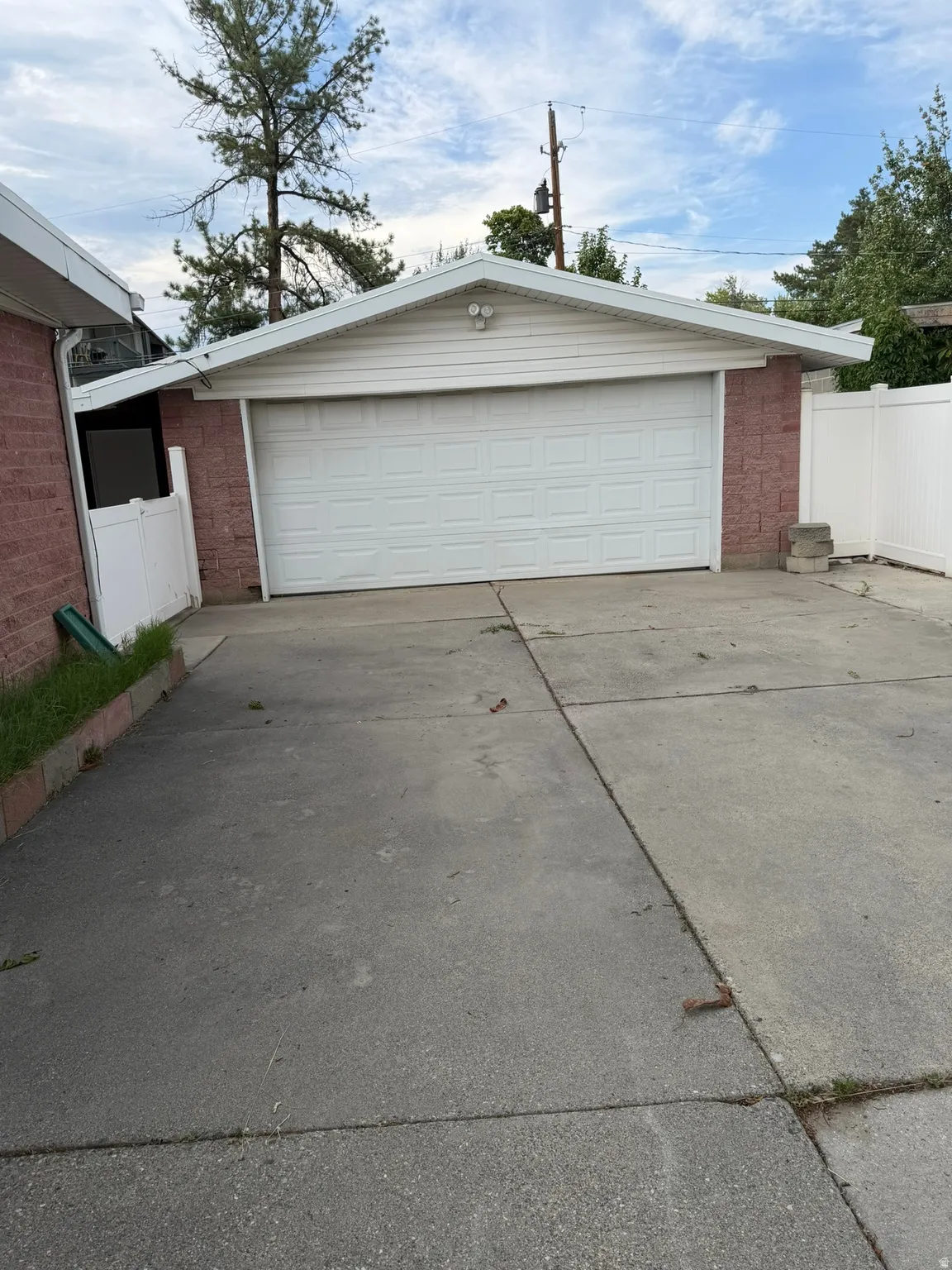 Attached garage with a white panel door and brick siding