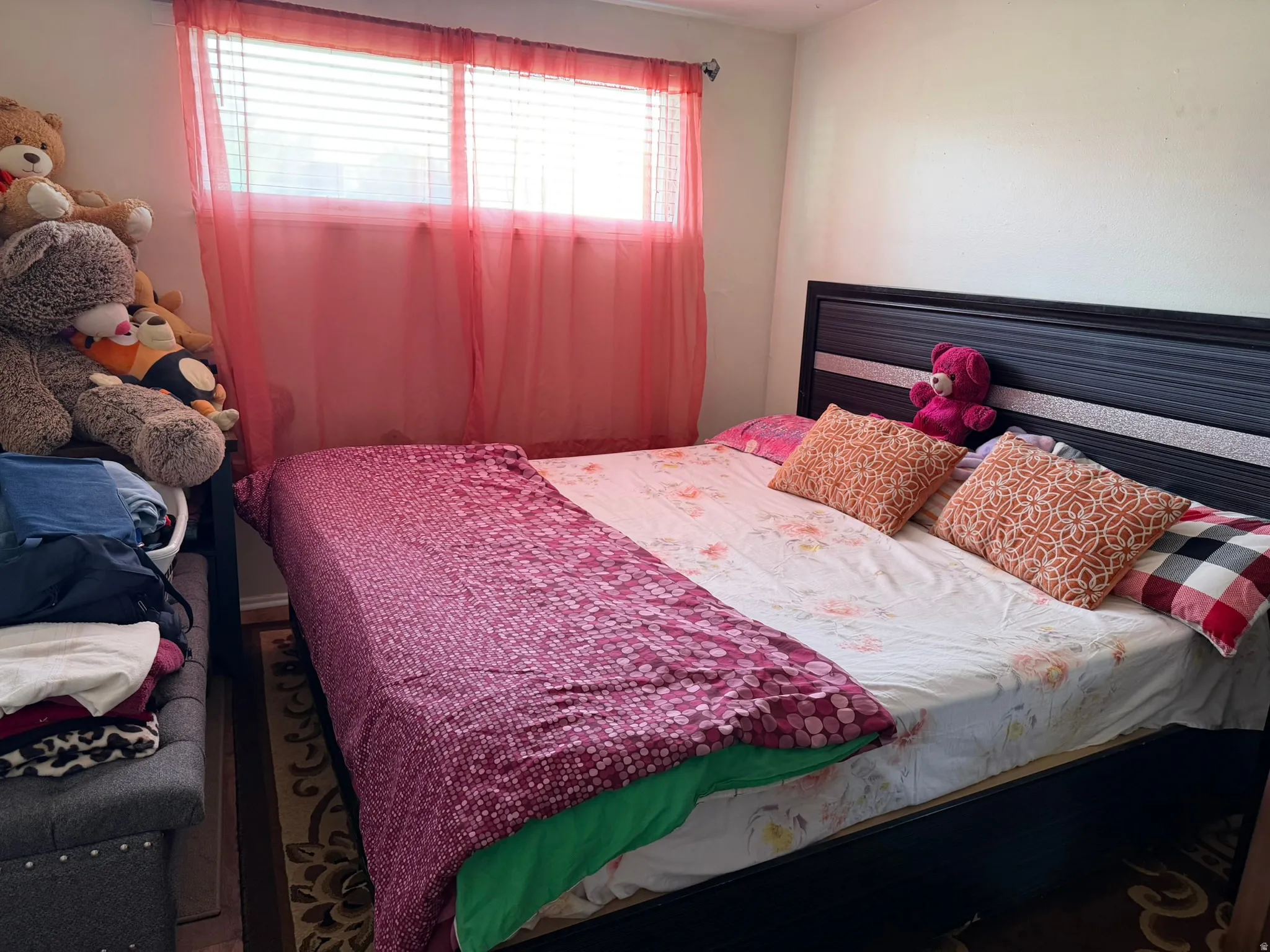Window with horizontal blinds and sheer pink drapes