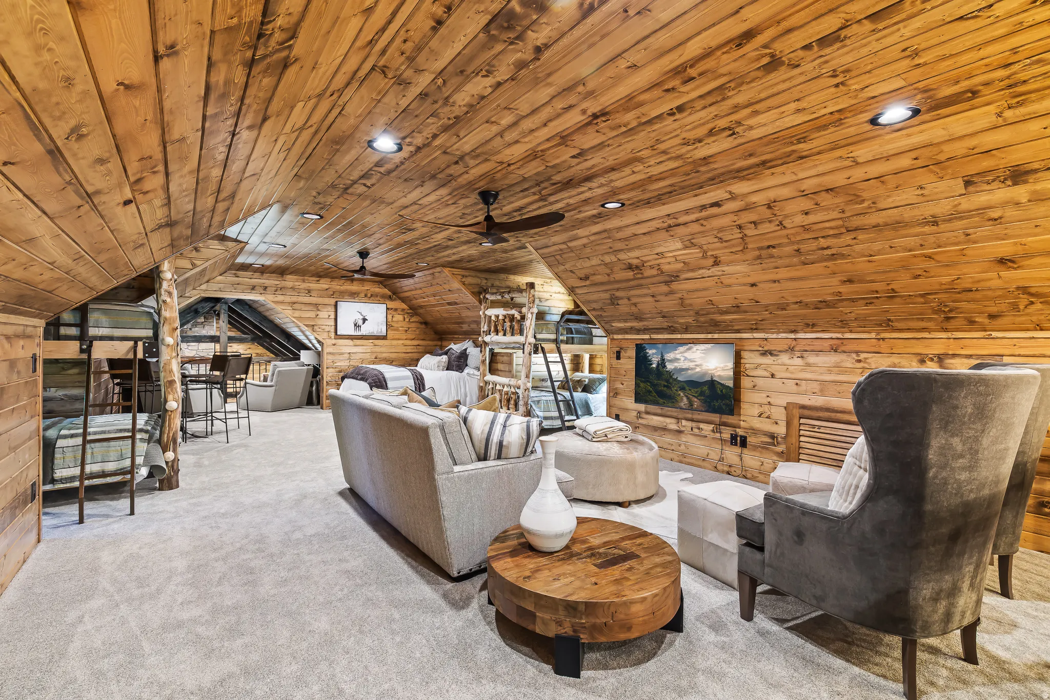 Vaulted wood-paneled ceiling, recessed lighting, wood-paneled walls, built-in television, and carpeted flooring