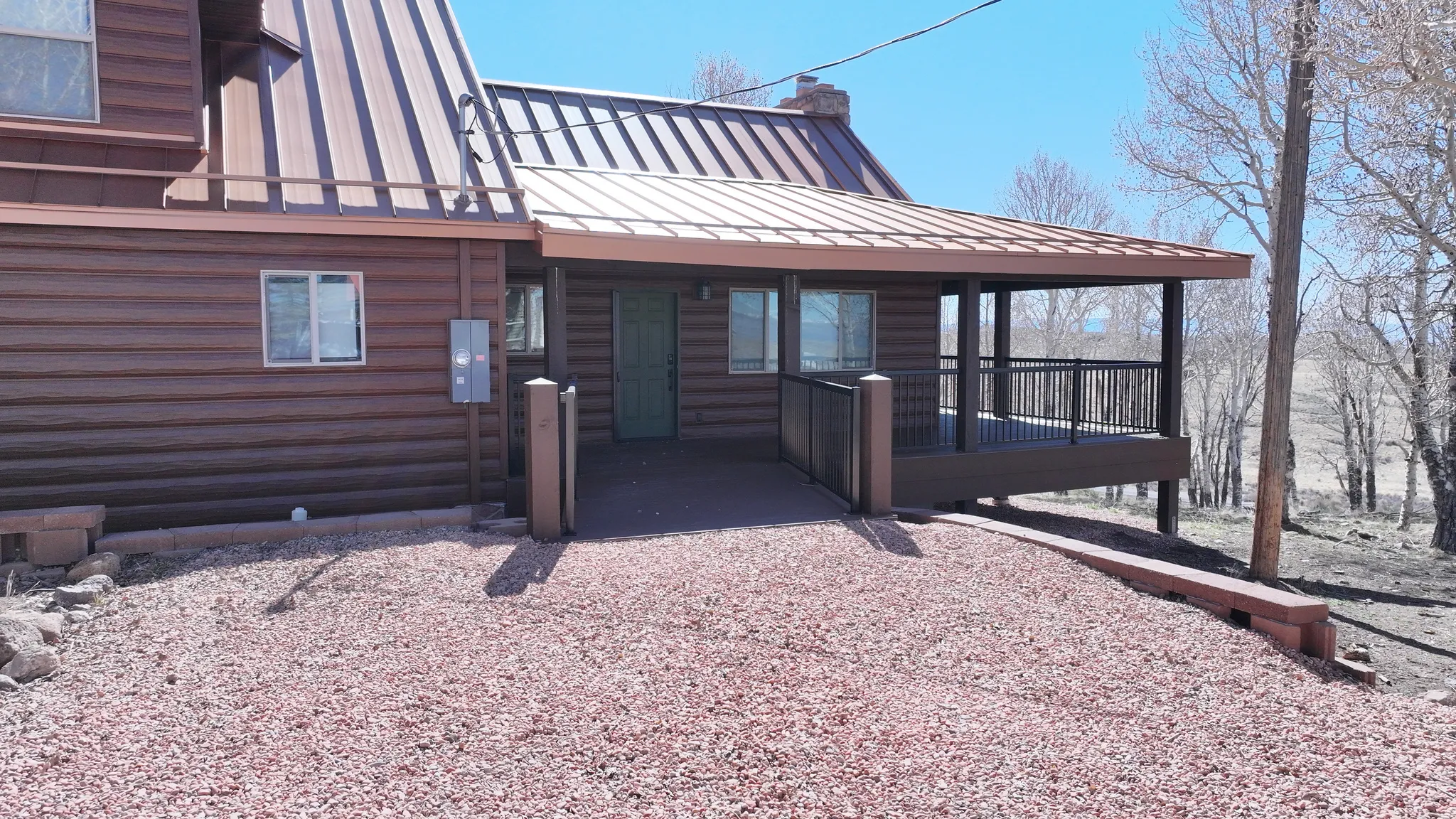 Log-style exterior with a covered porch and metal roofing