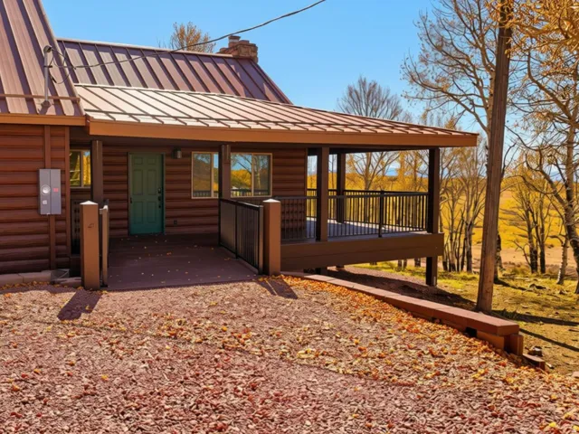 Log cabin exterior with a covered porch and brown metal roof