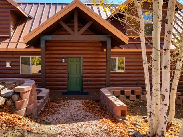 Wood-paneled facade with a standing seam metal roof and a covered entryway