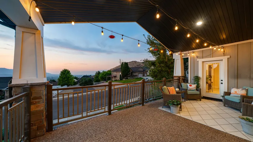 Expansive covered patio featuring a two-tone floor surface, painted siding, and a white framed glass door