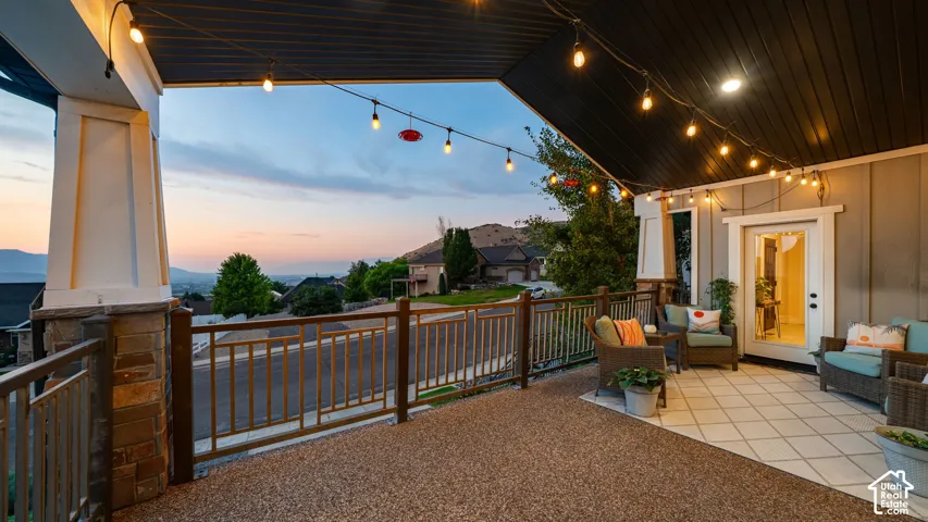Expansive covered patio featuring a two-tone floor surface, painted siding, and a white framed glass door