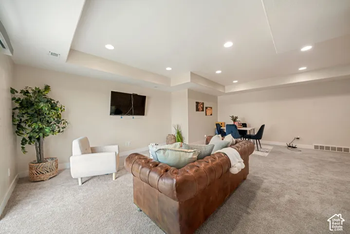 Recessed lighting illuminates the carpeted floor and neutral-toned walls