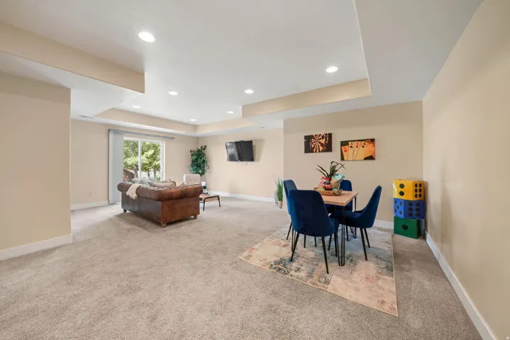 Recessed lighting, light-colored walls, sliding glass door, and carpeted flooring