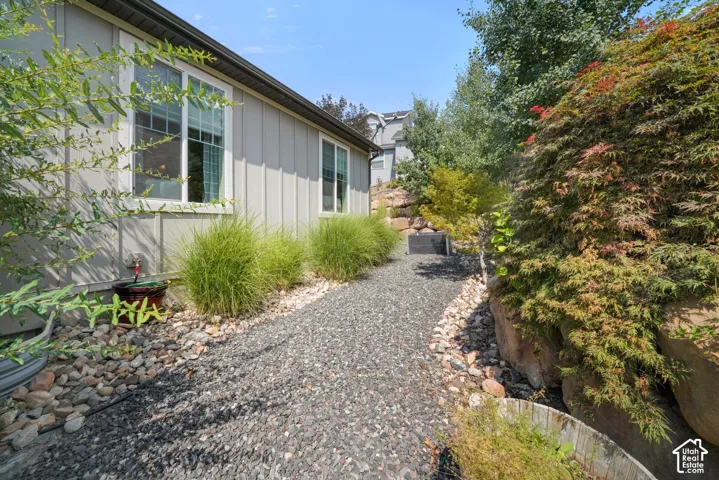 Gravel pathway bordered by river rock and established landscaping