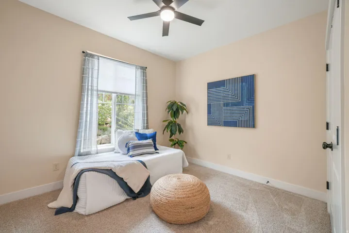 Recessed window with a window seat, light-colored walls, carpeted flooring, and a ceiling fan with integrated lighting