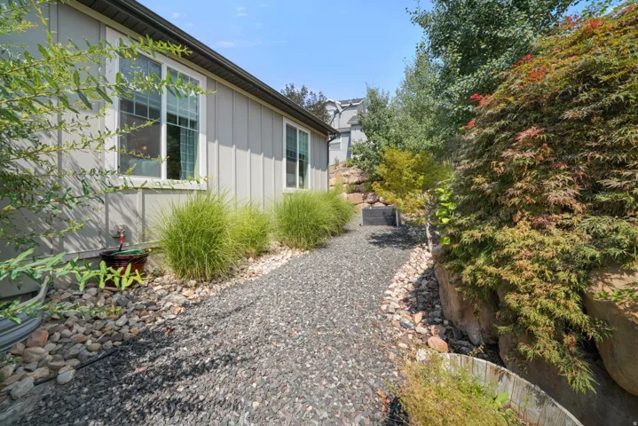 Gravel pathway bordered by river rock and established landscaping