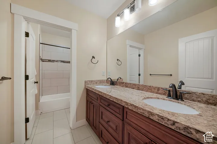 Double vanity with undermount sinks, stone countertop, and dark-finish faucets