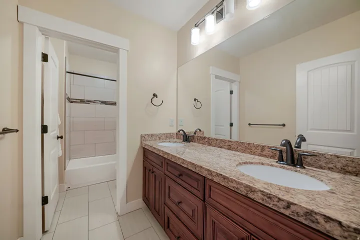 Double vanity with undermount sinks, stone countertop, and dark-finish faucets