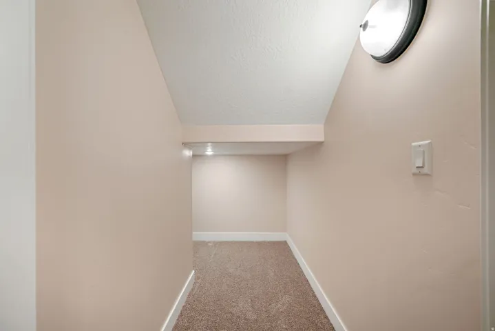 Carpeted alcove with recessed lighting and a flush-mount ceiling fixture