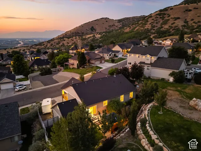 Hillside property with a terraced, rock-lined landscape and mature trees