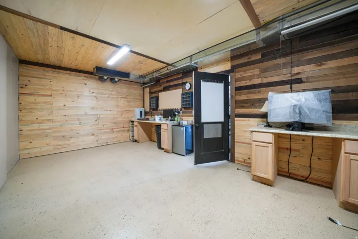 Wood plank wall finishes, wood plank ceiling, light-colored flooring, built-in cabinetry, and integrated countertops
