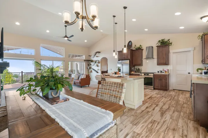 Vaulted ceilings, wood-finish flooring, and a kitchen island with pendant lighting