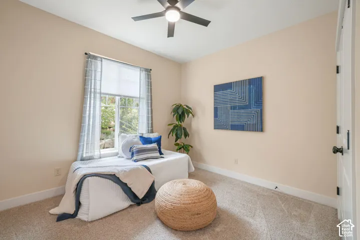 Recessed window with a window seat, light-colored walls, carpeted flooring, and a ceiling fan with integrated lighting