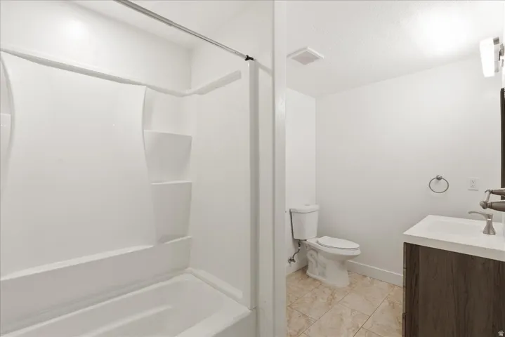 White tub and shower combination with built-in shelving