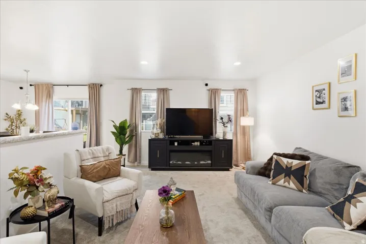 Open-concept interior featuring recessed lighting, a built-in entertainment center with an electric fireplace, and light-toned wall finishes