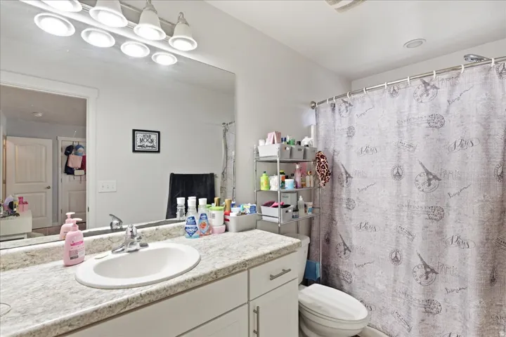 Vanity with integrated sink, expansive mirror, and overhead lighting fixture