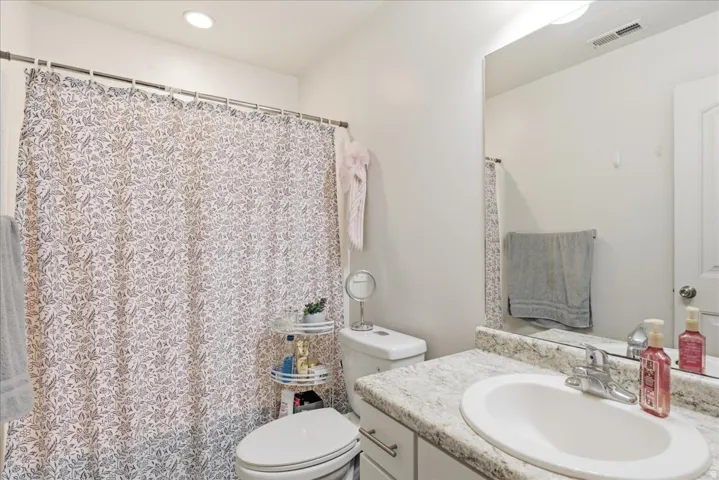 White vanity with a neutral-toned countertop and an integrated sink
