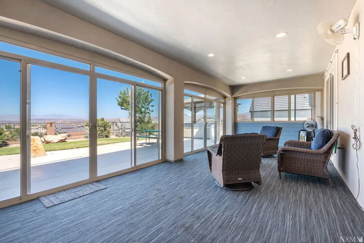 Enclosed patio featuring expansive sliding glass doors, recessed lighting, and a textured flooring