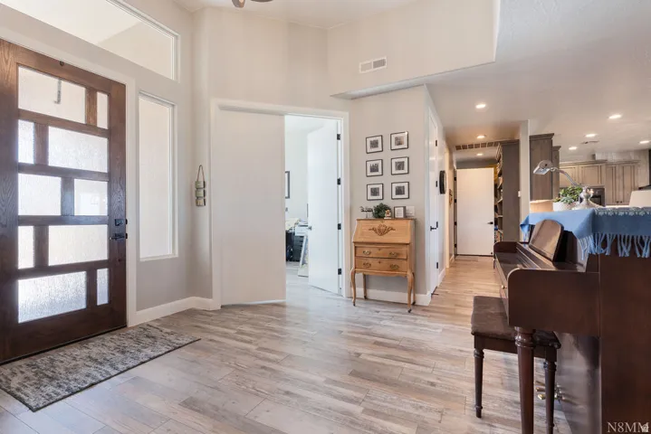 Contemporary wood-panel entry door with frosted glass panels and transom window