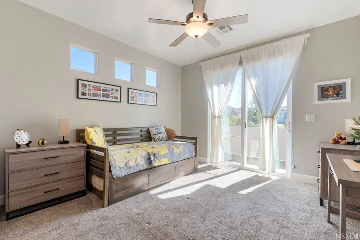 Wall-to-wall carpeting, multiple clerestory windows, and a ceiling fan with integrated lighting