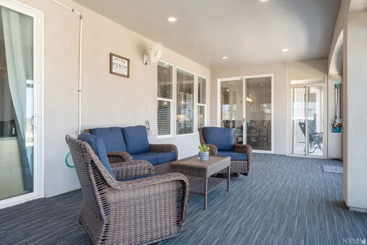 Covered patio featuring recessed lighting, a ceiling fan, and multiple sliding glass doors