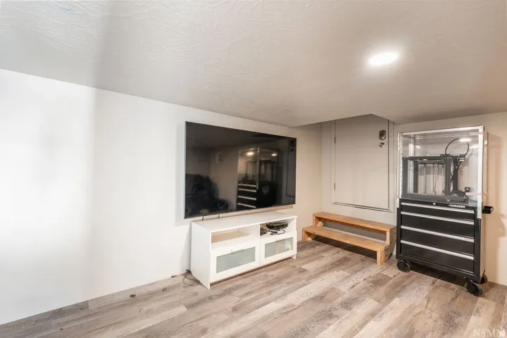 Recessed ceiling lighting, durable wood-finish flooring, and white painted walls