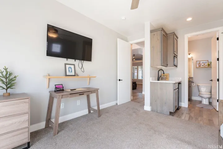 Built-in wet bar with wood-finish cabinetry, countertop, and a black gooseneck faucet