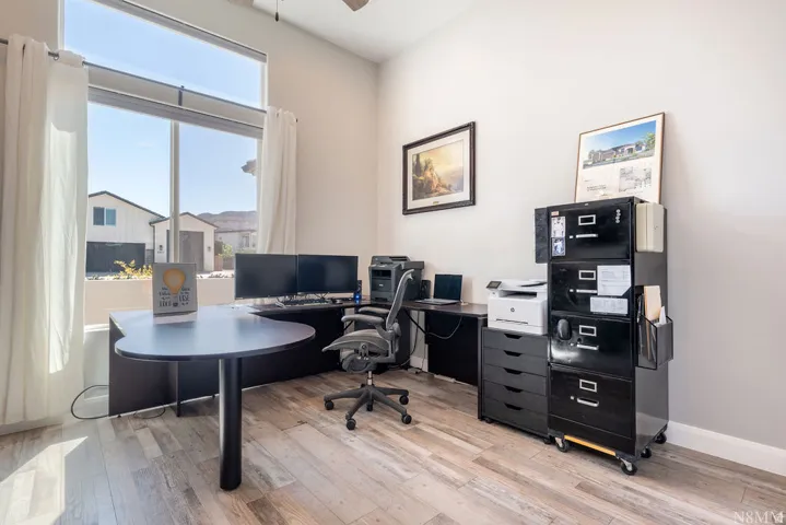 Wood-finish flooring, high ceilings, and large windows with transom above