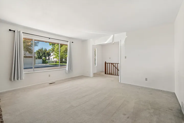 Expansive room featuring light-toned carpeting and a large multi-pane window
