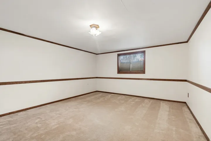 Carpeted flooring, white walls, and a window with blinds